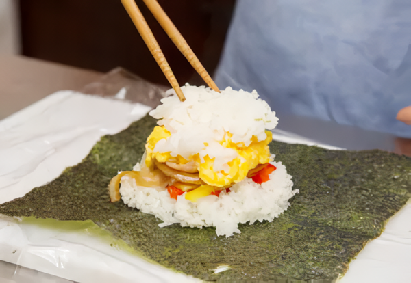 海苔の真ん中に茶碗半分のご飯を広げ、薄切りにしたパプリカ（赤・黄）→焼肉→スクランブルエッグ→もう一度茶碗半分のご飯を重ねる。