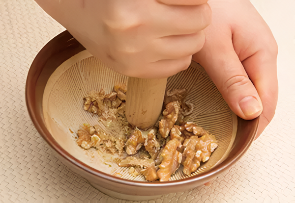 ボウルに磨りつぶしたクルミと、〈調味料〉を入れて泡だて器でよく混ぜ合わせ、なめらかになったら豆腐と野菜を加えて和える。クルミはすり鉢で砕き、粗く磨りつぶしておく。