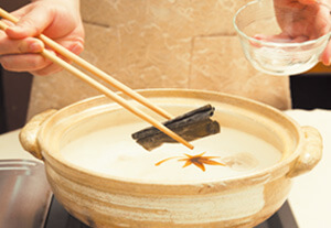 鍋を火にかけ、沸騰したら昆布を取り出す。軽く沸騰した状態で食べる分だけ豚肉や野菜などを入れて火を通す。