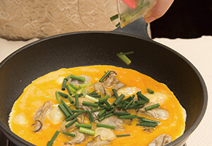 フライパンでサラダ油を熱し牡蠣を炒める。牡蠣がふっくらと膨らんできたら、4の卵液と万能ねぎを加えて軽くかき混ぜて形を整える。