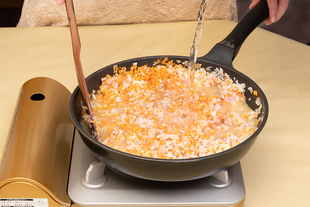レンズ豆を加えて具材がかぶるぐらいまで水を注いで強火に。沸騰したら弱めの中火にしてコトコト煮込む。レンズ豆を加えたら、具材が浸る程度に水を注ぐ。