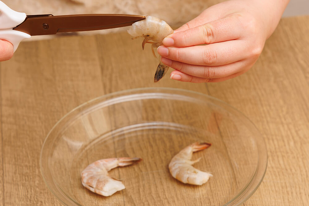 エビの頭側からキッチンハサミで背の部分に浅く切り込みを入れる。背ワタがある場合は、竹串ですくって取り除く。