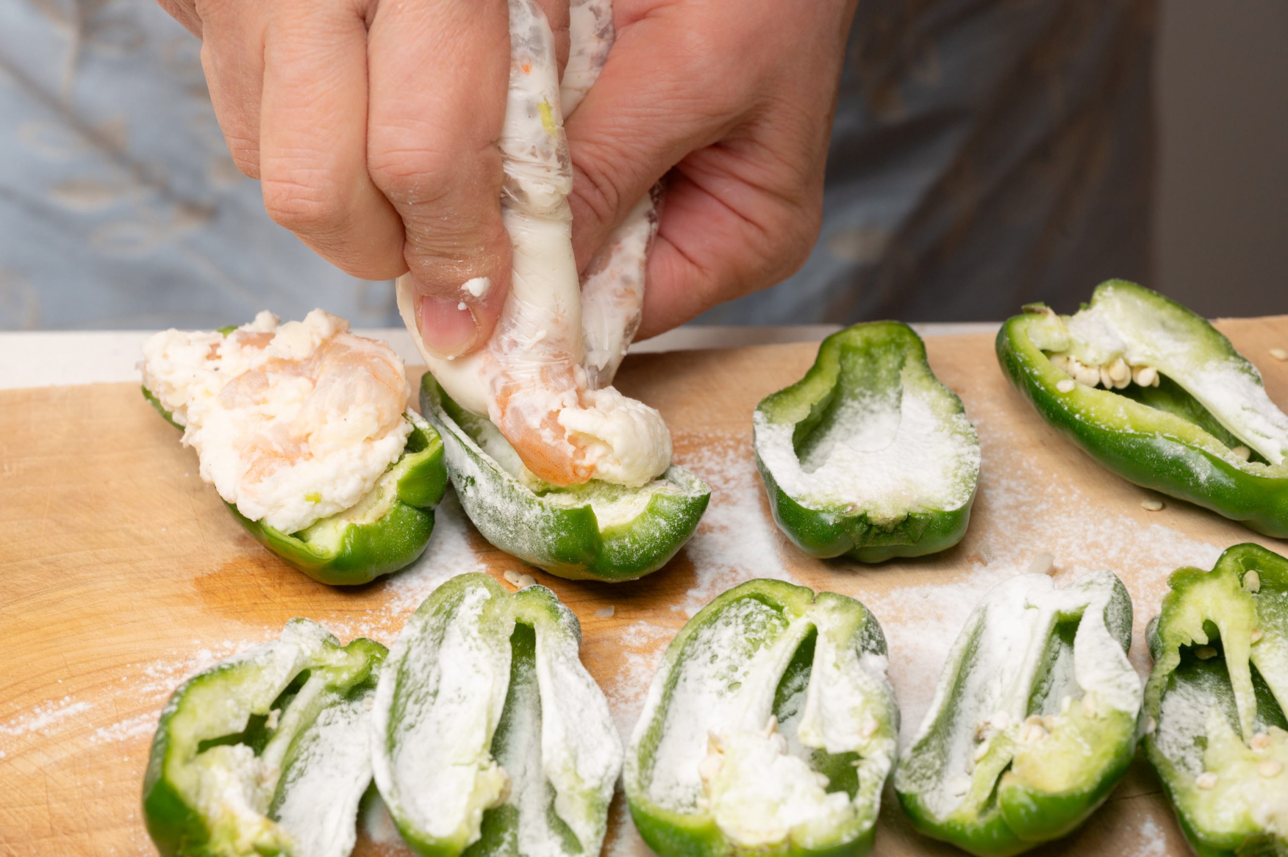 2の袋の下端を切り取り、そこから絞り出してピーマンに等分に詰める。