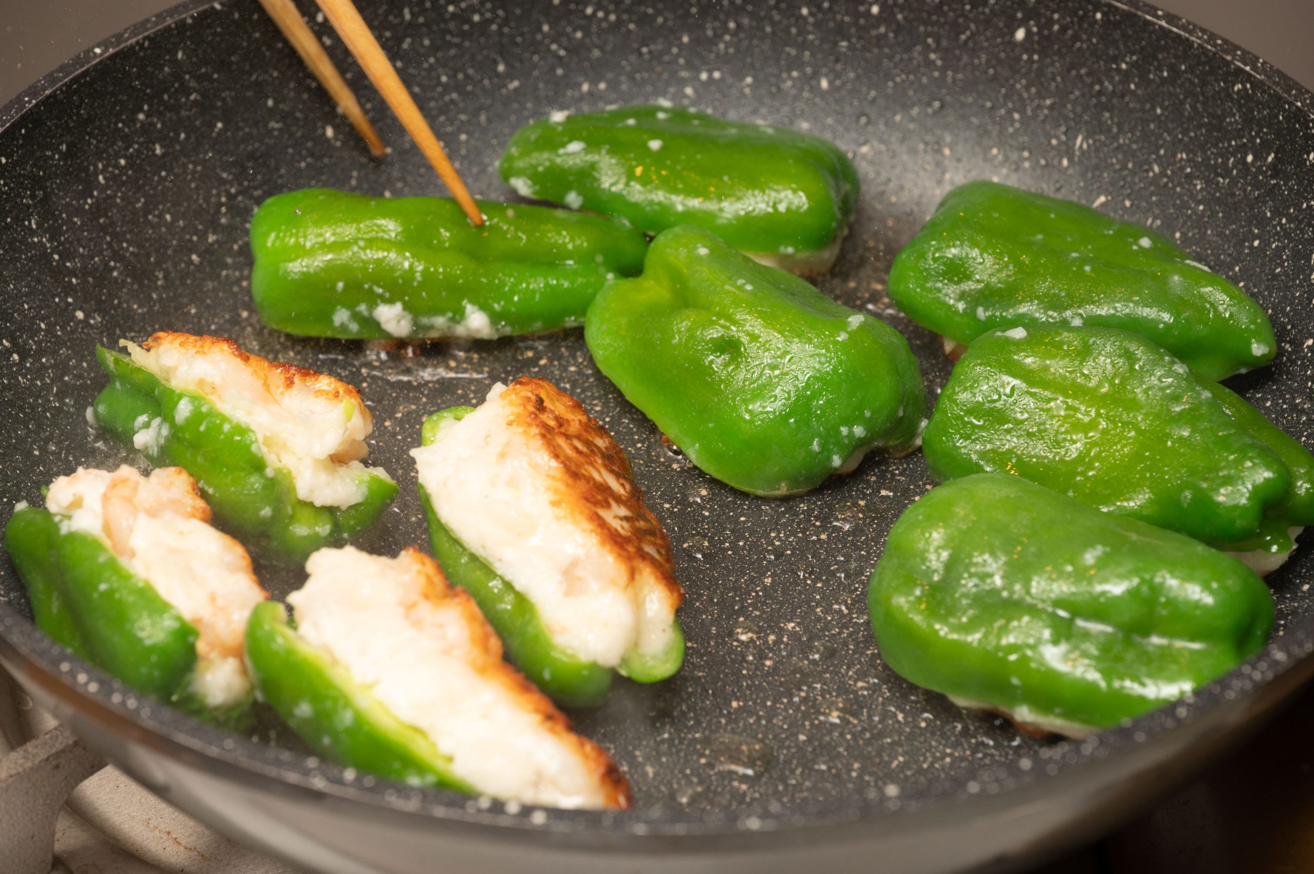 フライパンに米油を引き、3を詰め物した面を下にして並べ、蓋をして焼き、ひっくり返してピーマンの方も焼く。春のお弁当なのでこれに出汁巻き卵と豆ごはんのおむすびを添える。